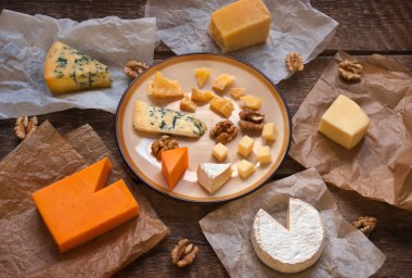 Assorted cheeses on the wooden table clipart