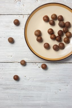 Macadamia fıstığı beyaz arka plan üzerinde plaka