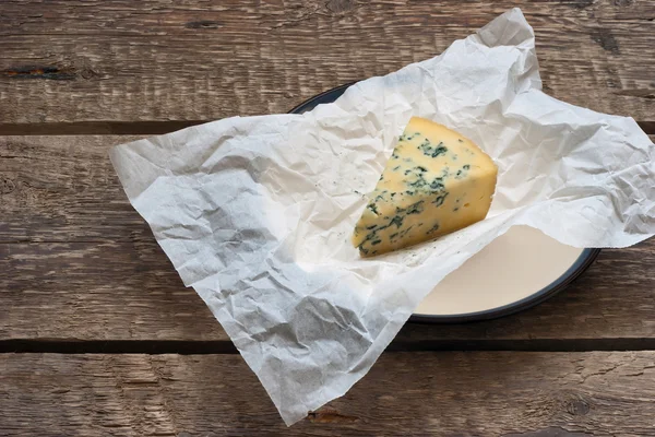 Cheese with a blue mold on the paper — Stock Photo, Image