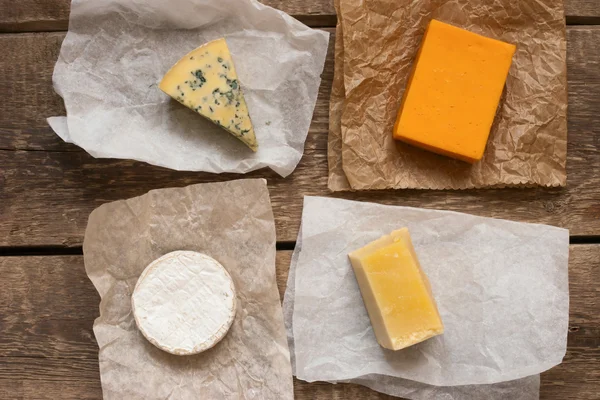 Assorted cheeses on the wooden table — Stock Photo, Image