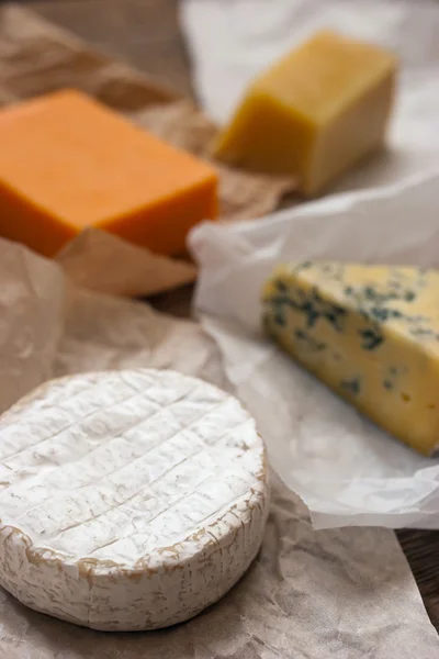 Assorted cheeses on the wooden table — Stock Photo, Image