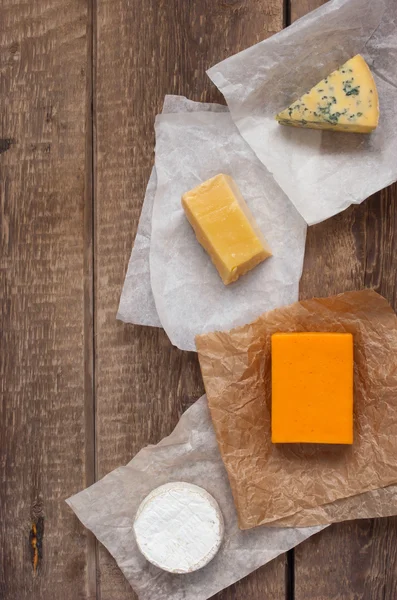 Assorted cheeses on the wooden table — Stock Photo, Image