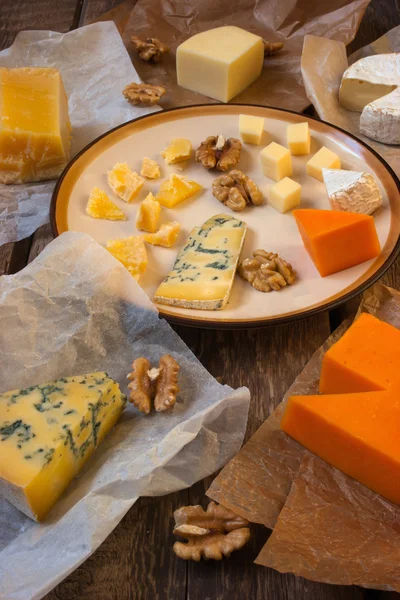 Assorted cheeses on the wooden table — Stock Photo, Image