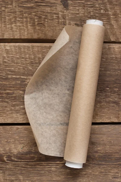 Открытый рулон бумаги на деревянном фоне стола — стоковое фото