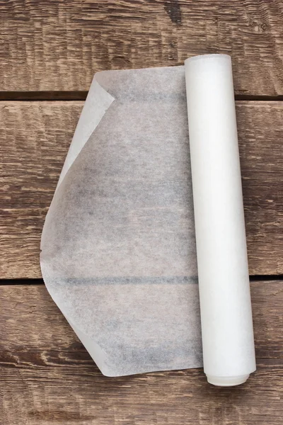 Открытый рулон бумаги на деревянном фоне стола — стоковое фото