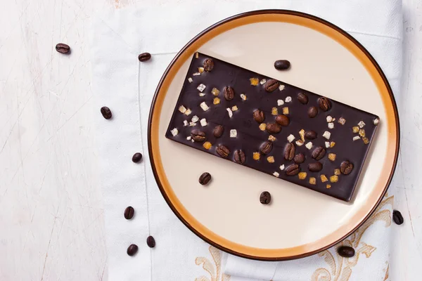 Chocolate con ralladura y granos de café en la mesa blanca —  Fotos de Stock