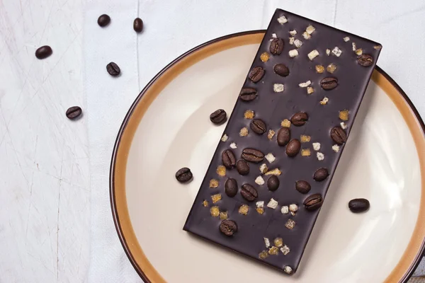 Chocolate con ralladura y granos de café en la mesa blanca —  Fotos de Stock