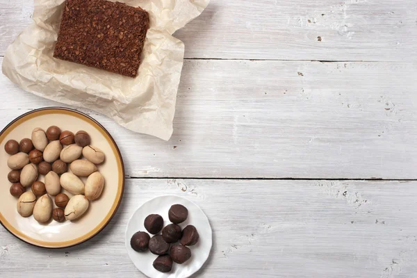 Nueces, dulces de trufa y pastel de chocolate en el fondo blanco — Foto de Stock