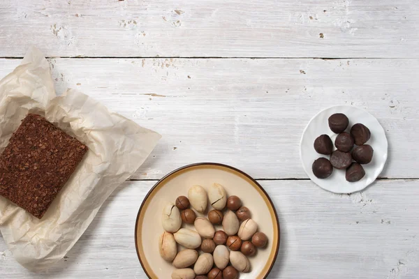 Nueces, dulces de trufa y pastel de chocolate en el fondo blanco — Foto de Stock