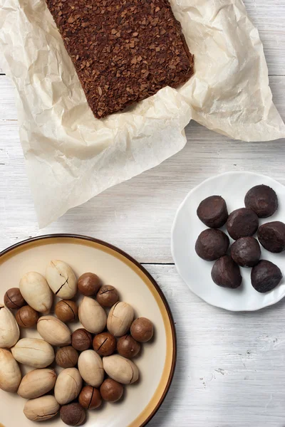 Орехи, конфеты трюфели и шоколадный торт на белом фоне — стоковое фото