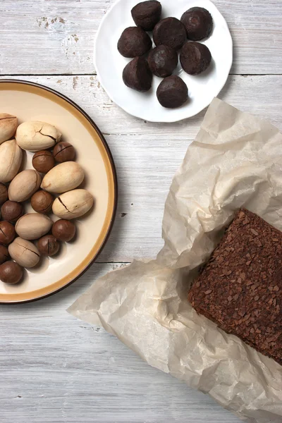 Nozes, trufas doces e bolo de chocolate no fundo branco — Fotografia de Stock