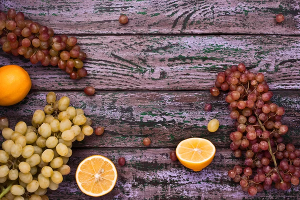 Ассорти фруктов рамка на фиолетовом фоне — стоковое фото