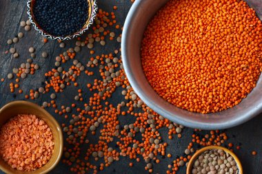 Alüminyum ve seramik yemekleri ile karanlık bir arka plan üzerinde mercimek