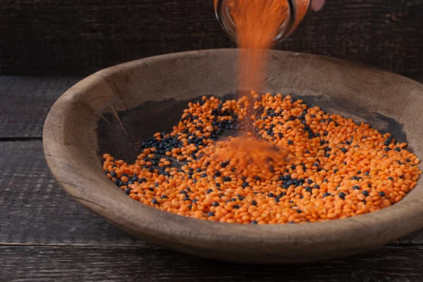 Antika ahşap tabak bir woode üzerinde siyah ve kırmızı mercimek ile doldurma — Stok fotoğraf