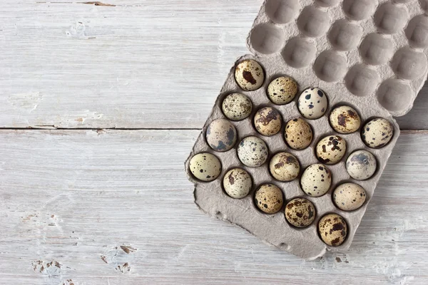 Huevos de codorniz en el embalaje de cartón en la mesa blanca — Foto de Stock