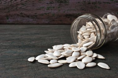 Ahşap masa üzerinde cam kavanoza kabak çekirdeği