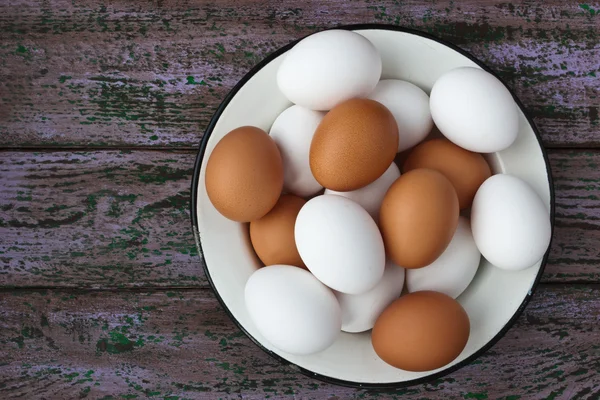 Ovos de galinha em um copo e um prato de metal nas placas roxas — Fotografia de Stock
