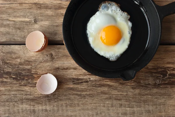 Huevos revueltos en una sartén de hierro sobre la mesa rústica —  Fotos de Stock