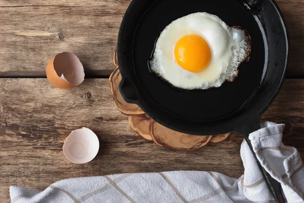 Huevos revueltos en una sartén de hierro sobre la mesa rústica —  Fotos de Stock