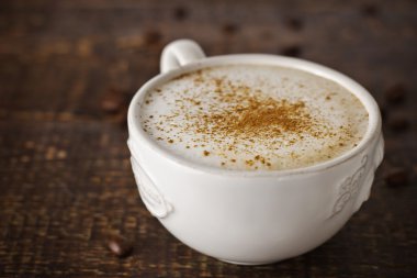 Ahşap masa üzerinde bir cappuccino ile beyaz bir provence Kupası