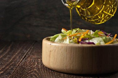 Cam sürahi içine bir woode sebze salataya zeytinyağı dökülen