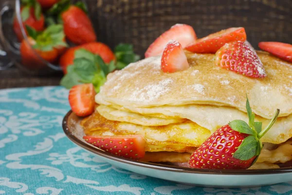 Hot pancakes with strawberries and honey on the ceramic plate — Stock Photo, Image