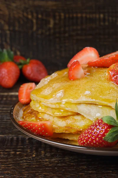 Hot pancakes with strawberries and honey on the ceramic plate — Stock Photo, Image