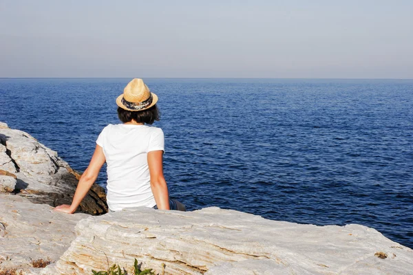 Fille en chapeau de paille regarder à la mer — Photo