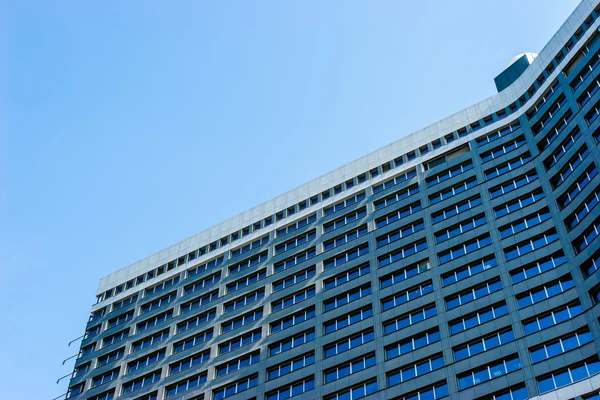 Mavi gökyüzü arka plan üzerinde modern bina cephe — Stok fotoğraf