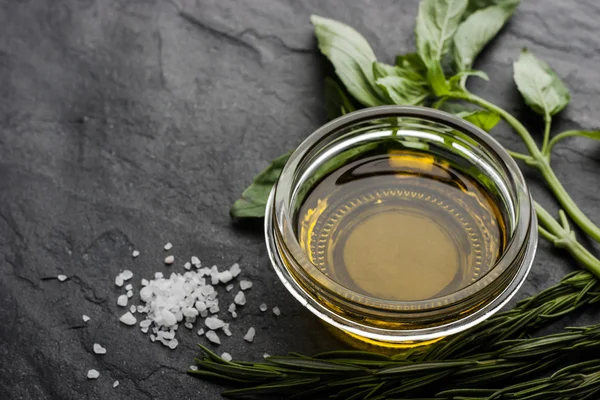 Olive oil on the glass bowl with different greens — Stock Photo, Image