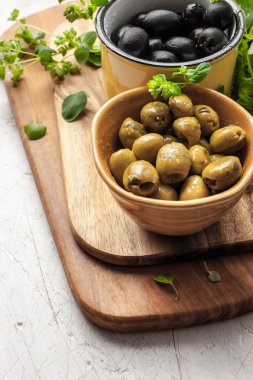 Beyaz ahşap masa mutfak tahtada kekik ile çeşitli zeytin