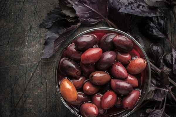 Kalamata-Oliven auf der Glasschale mit rotem Basilikum — Stockfoto
