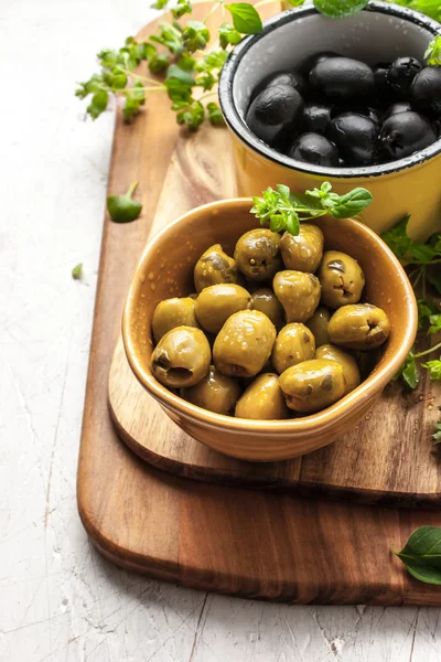 Assorted olives with oregano on the white wooden table — Stock Photo, Image