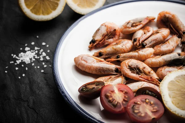 Grilled prawns with tomatoes and salt on the ceramic plate — Stock Photo, Image