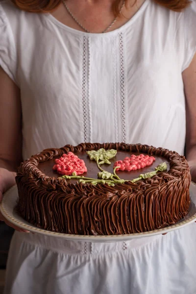 Kiev cake met chocolade crème in de vrouw handen verticale — Stockfoto