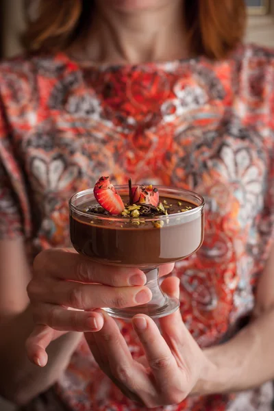 La crema de chocolate con la fresa y el pistacho en las manos de la mujer —  Fotos de Stock