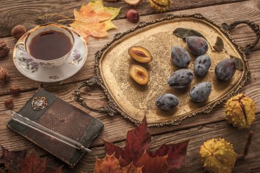 Autumnal still life with gift of nature , vintage notebook and tea with film filter effect