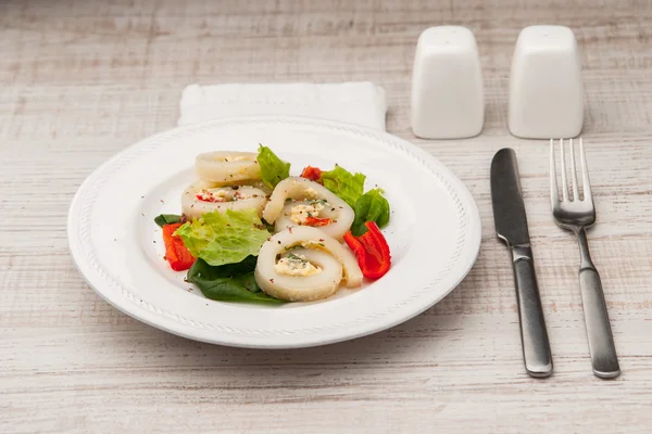 Rollo de calamares con queso y verduras en el plato de cerámica con cubiertos —  Fotos de Stock