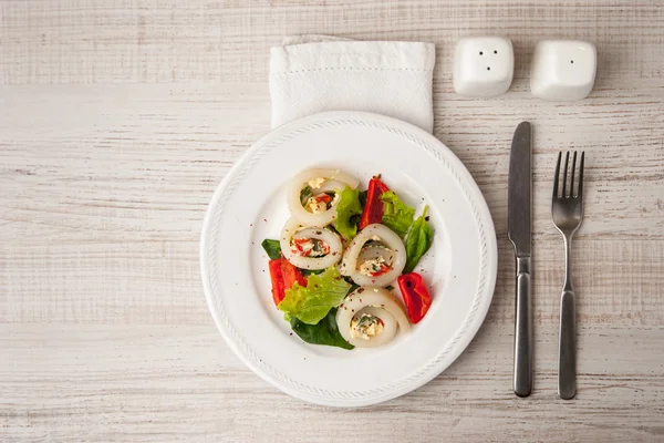 Squid roll with cheese and vegetables on the ceramic plate with cutlery top view — Stock Photo, Image