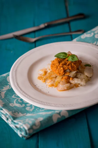 Cod with sauce romanesco on the cyan table — Stock Photo, Image