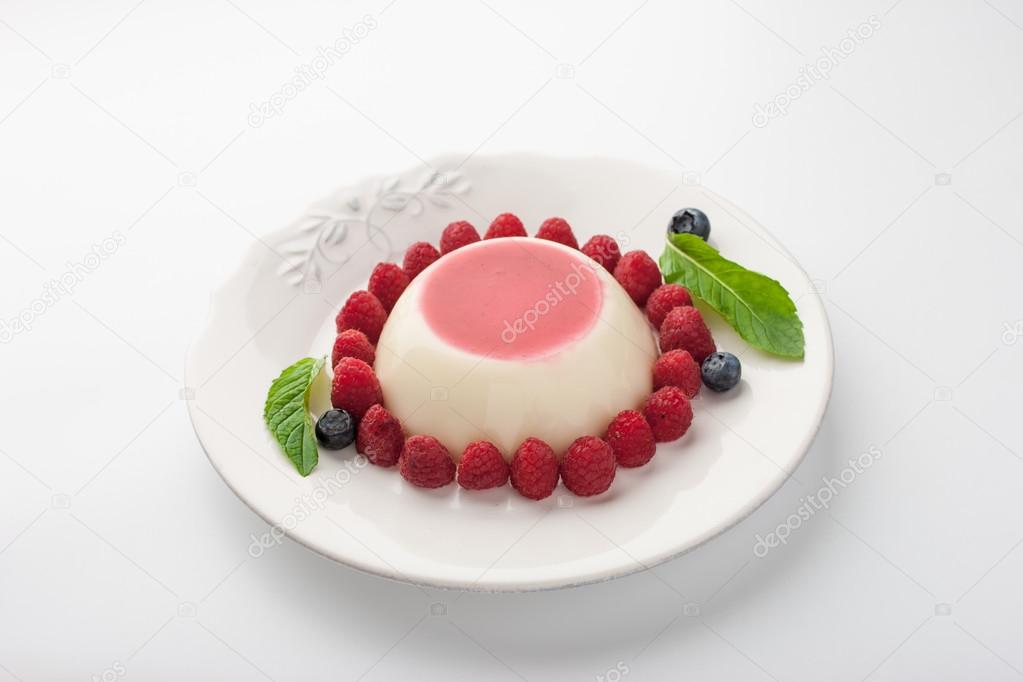 Panna cotta with berries and mint on the white plate