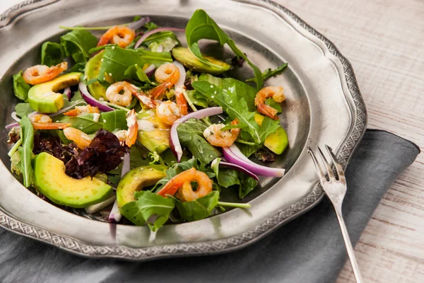 Prawns and avocado salad on the vintage metal plate with fork — Stock Photo, Image