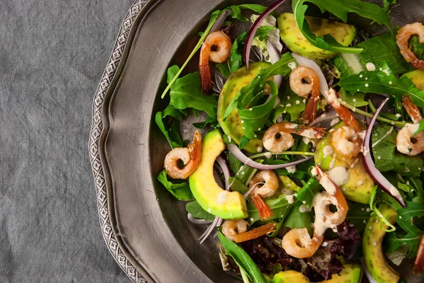 Ensalada con aguacate, rúcula y shtimps en la placa de metal vintage de cerca —  Fotos de Stock