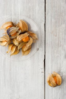 Ripe physalis on the white wooden table vertical