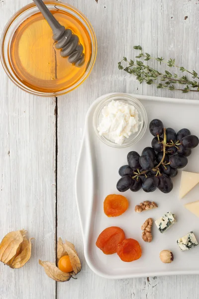 Frutas e queijos diferentes com mel e raminho de tomilho — Fotografia de Stock