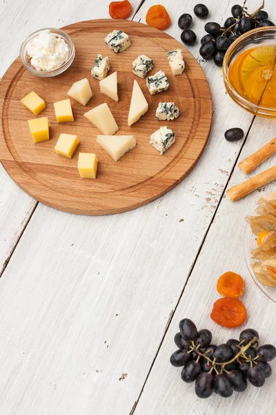 Prato de queijo com frutas diferentes e mel vertical — Fotografia de Stock