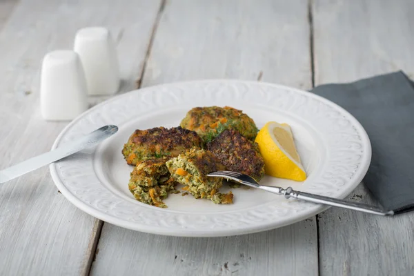 Rissoles com legumes e verduras na placa de cerâmica com talheres e fatia de limão — Fotografia de Stock