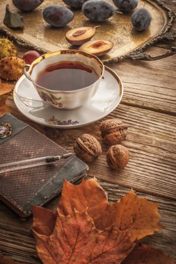 Cup of tea with gift of nature and vintage notebook with film filter effect vertical