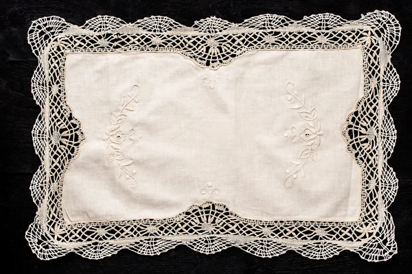 Old vintage napkin with lace border on the black wooden table — Stock Photo, Image