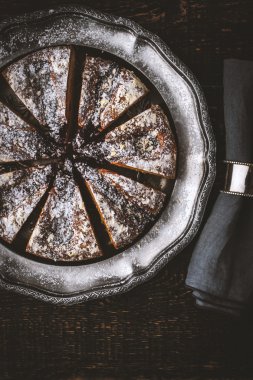 Peçete ile vintage metal plaka üzerindeki pudra şekeri ile pasta dilimlenmiş